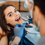 Dentist performing a repeat root canal treatment on a patient using advanced dental equipment in a modern clinic.