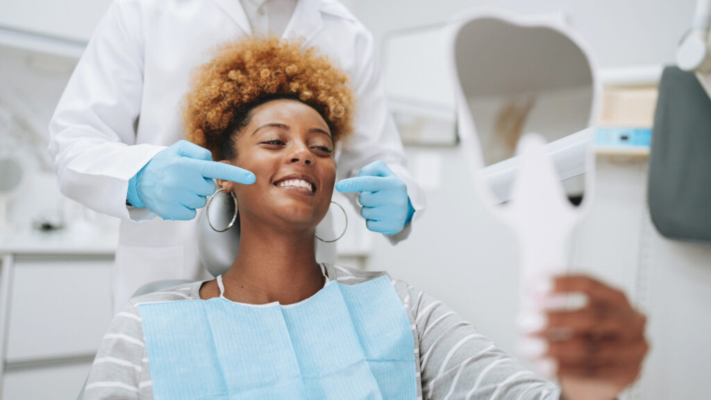 Woman in dentist office holding mirror