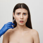 Worried woman receiving a botox injection near her eye.