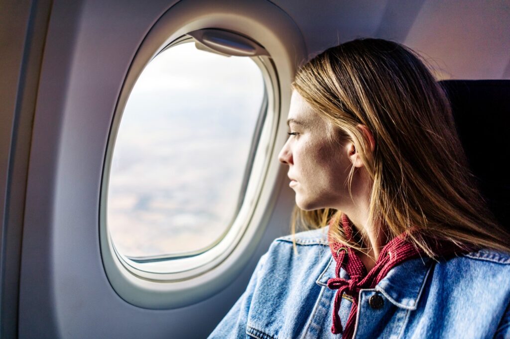woman-looking-out-airplane-window