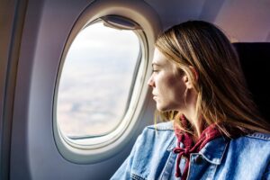 woman-looking-out-airplane-window